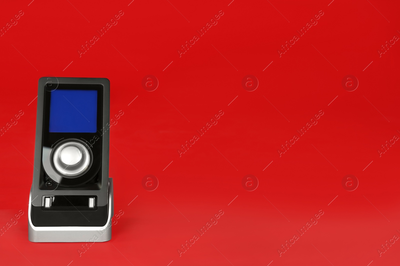Photo of Modern remote for audio speakers on red background, space for text