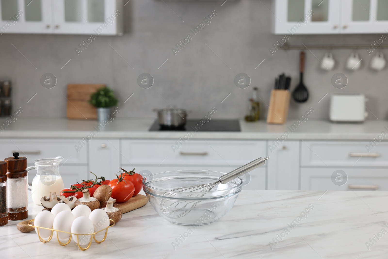 Photo of Whisk, bowl, and different ingredients on white marble table indoors, space for text