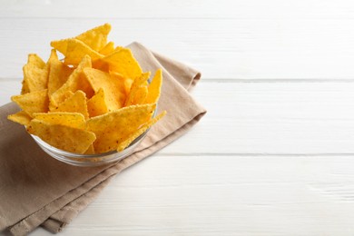 Tortilla chips (nachos) in bowl on white wooden table. Space for text