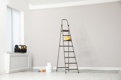 Photo of Ladder, decorator's tools and box with instruments in room