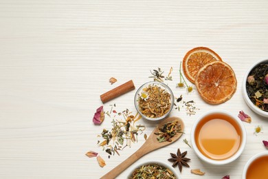 Flat lay composition with fresh brewed tea and dry leaves on white wooden table, space for text