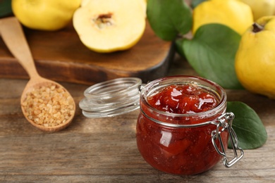 Photo of Delicious quince jam on wooden table, closeup