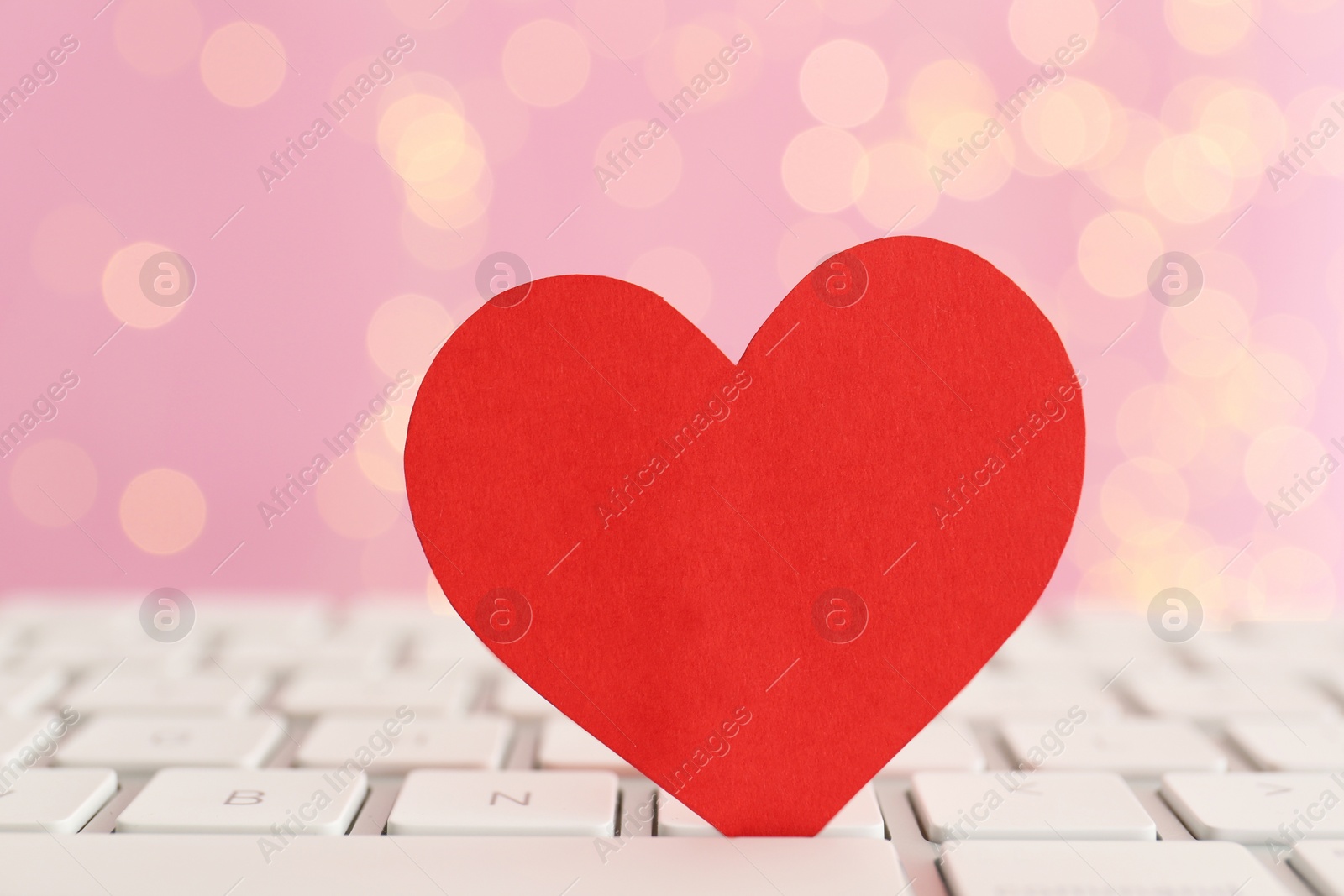 Photo of Red paper heart on computer keyboard, closeup. Online dating
