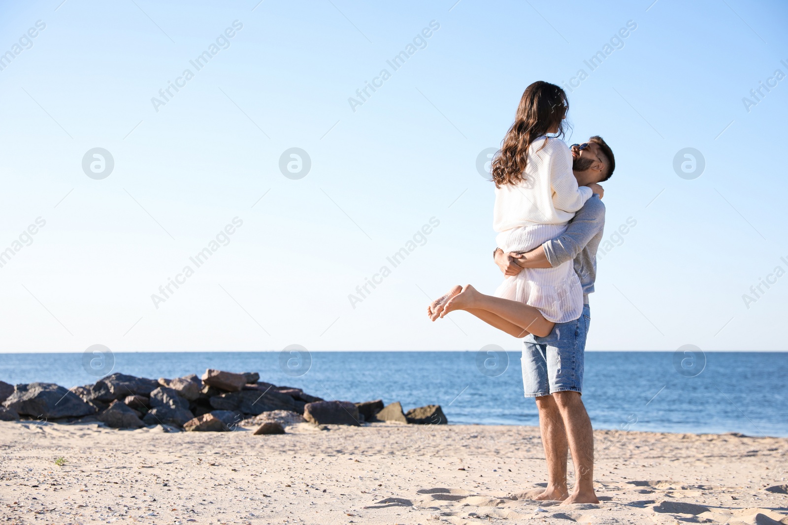 Photo of Happy young couple on beach near sea. Honeymoon trip