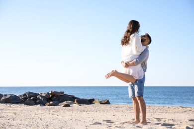 Happy young couple on beach near sea. Honeymoon trip