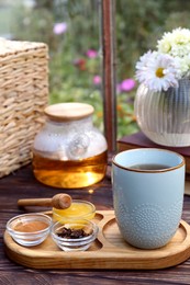 Photo of Tray with delicious tea and ingredients on wooden table