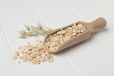 Scoop with oatmeal and florets on white wooden table
