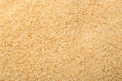 Photo of Granulated brown sugar as background, top view