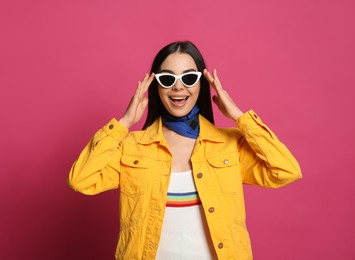 Photo of Fashionable young woman in stylish outfit with bandana on pink background