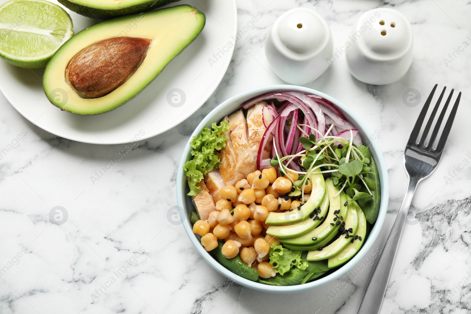 Photo of Delicious avocado salad with chickpea on white marble table, flat lay