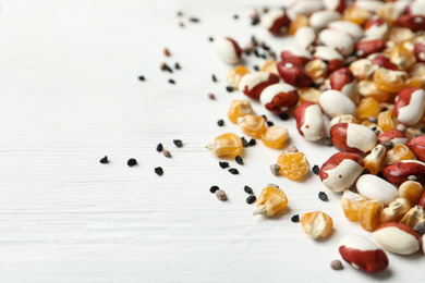 Photo of Mixed vegetable seeds on white wooden background, closeup
