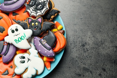 Photo of Tasty cookies and sweets for Halloween party on black table, top view. Space for text