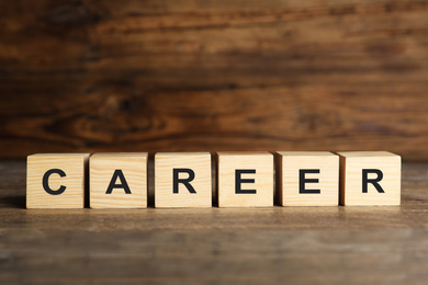 Photo of Cubes with word CAREER on wooden table. Space for text