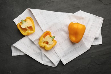 Kitchen towel with bell peppers on black table, flat lay