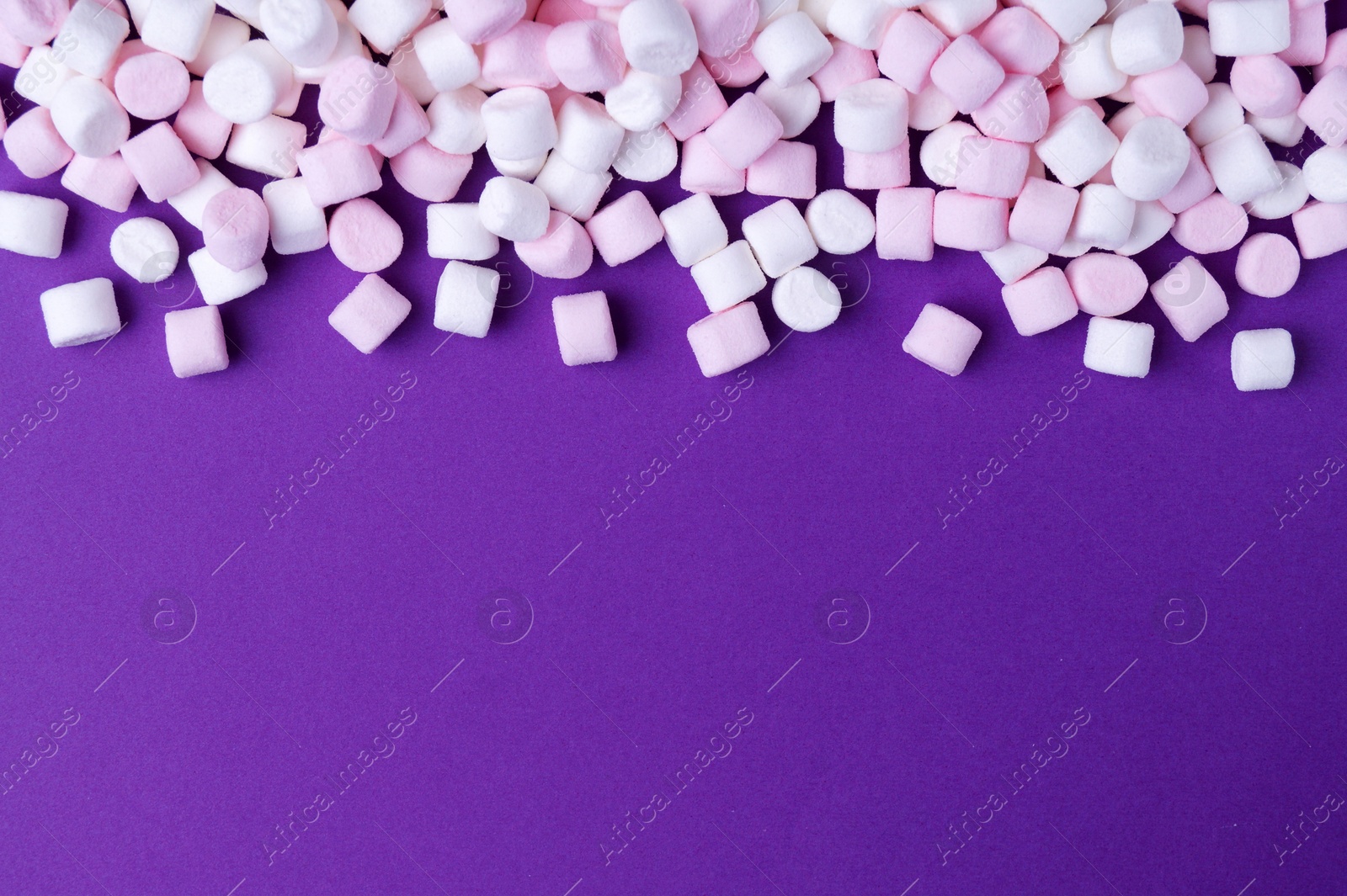 Photo of Delicious marshmallows on purple background, flat lay. Space for text