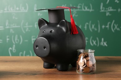 Photo of Scholarship concept. Piggy bank, graduation cap and coins on wooden table