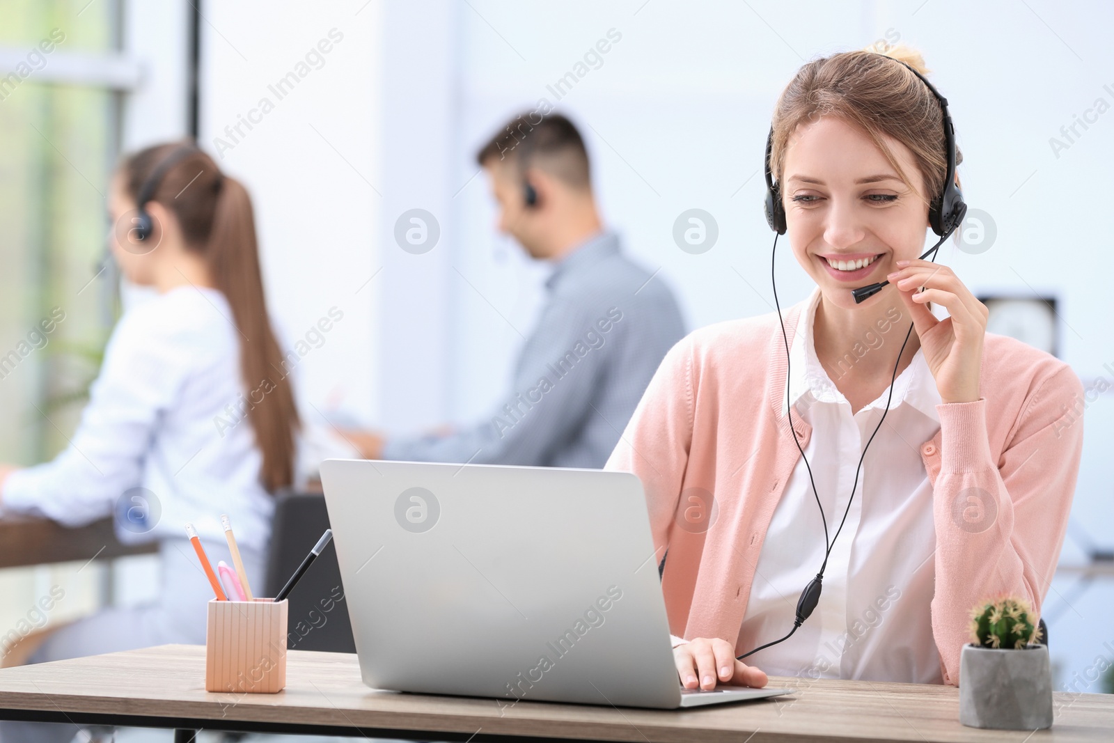 Photo of Female receptionist with headset at desk in office