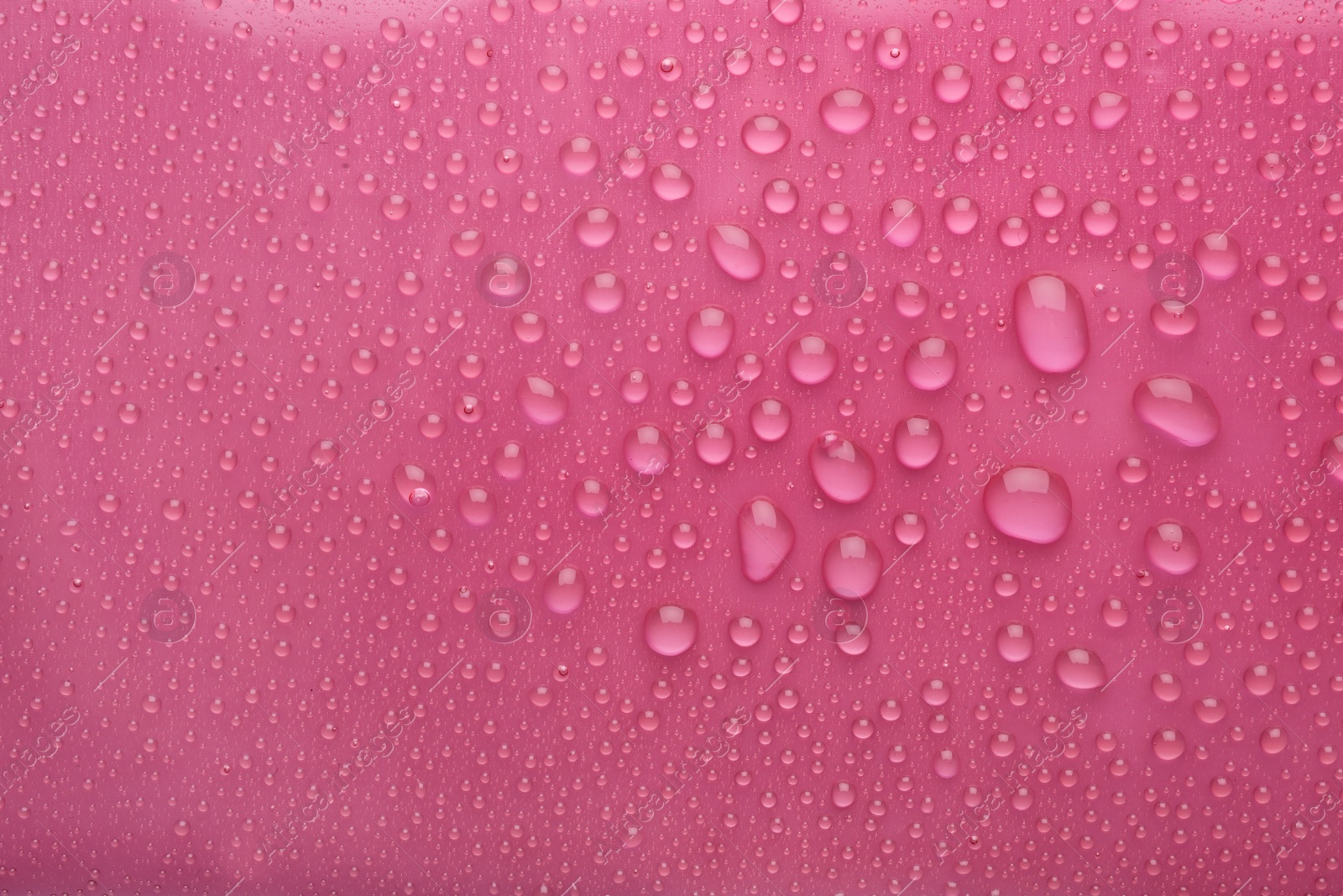 Photo of Water drops on pink background, top view