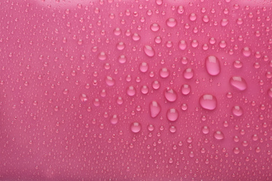 Water drops on pink background, top view