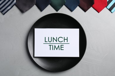 Image of Business lunch. Card with phrase Lunch Time, plate and different ties on light gray table, flat lay