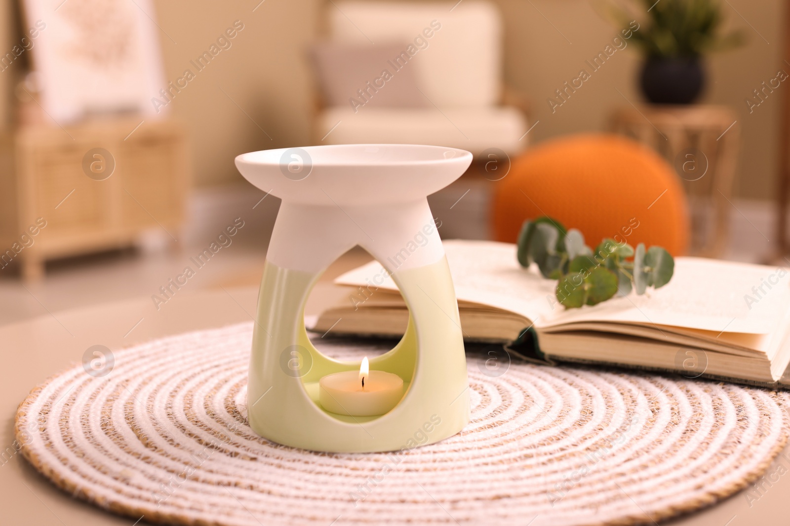 Photo of Stylish aroma lamp with small candle on table indoors
