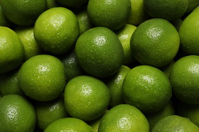 Photo of Fresh ripe limes with water drops as background, top view
