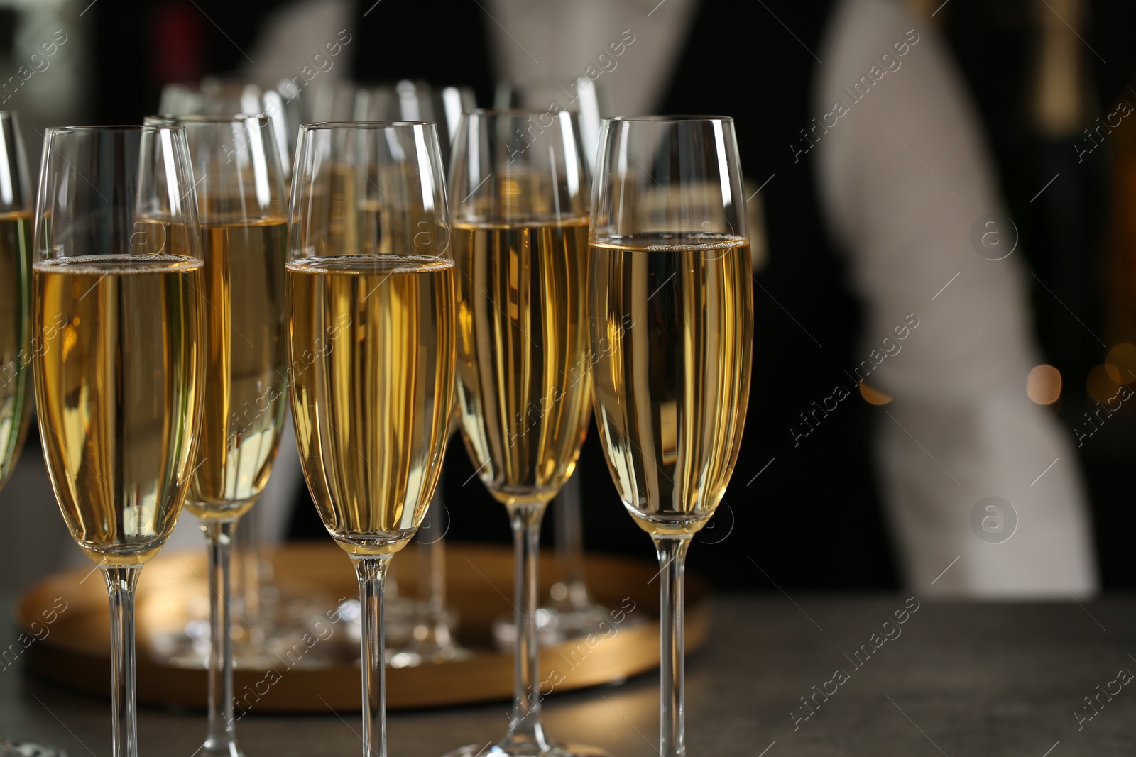 Photo of Glasses of champagne and waiter in restaurant, closeup