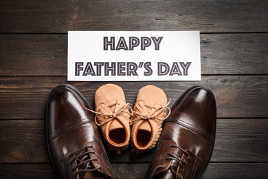 Photo of Flat lay composition with big and small shoes on wooden background. Father's day celebration