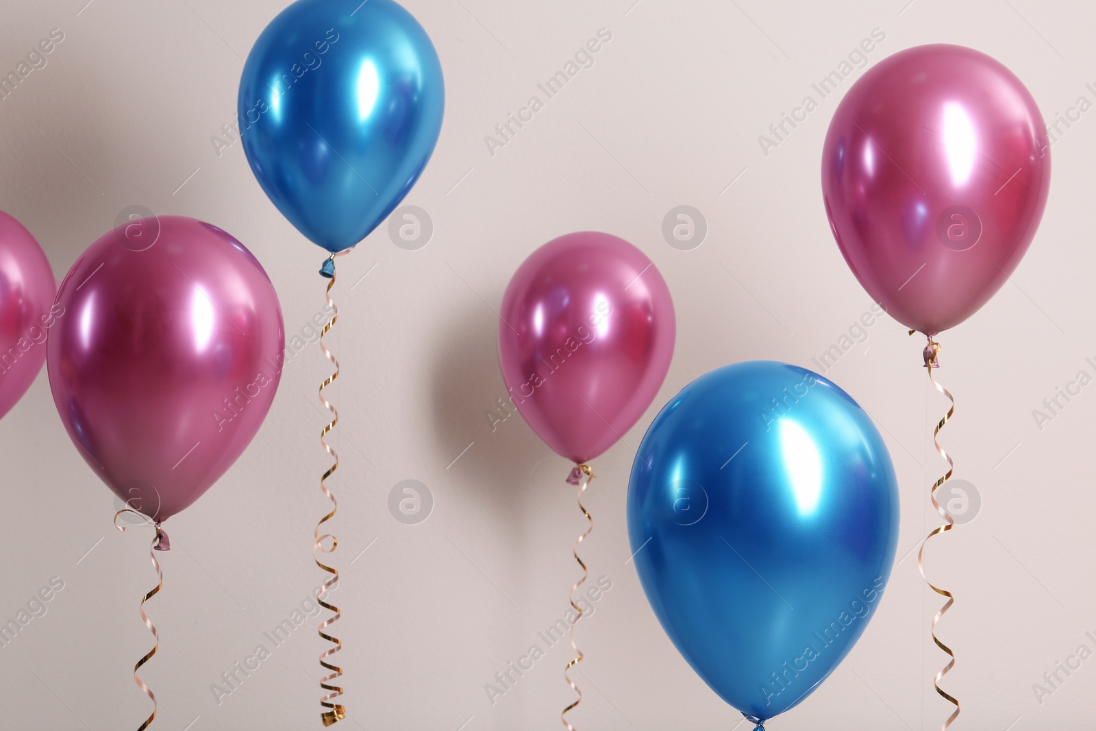 Photo of Color balloons with ribbons on white background