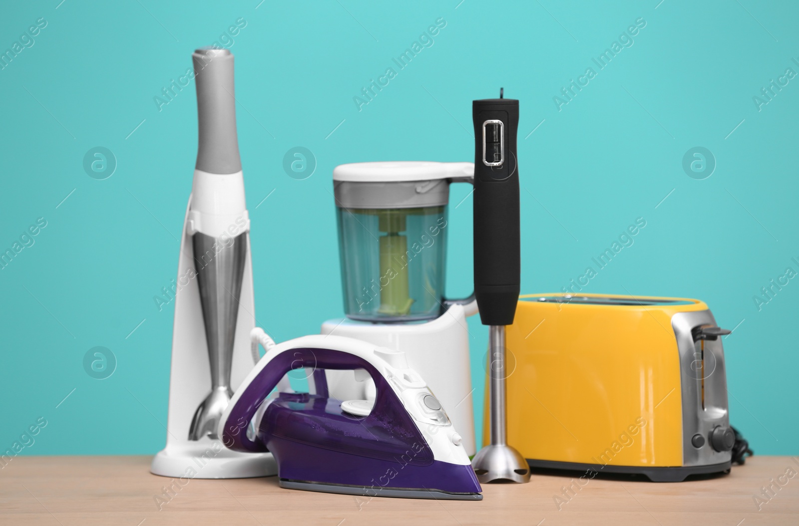 Photo of Household and kitchen appliances on table against color background. Interior element