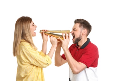 Young woman and man shouting into megaphone on white background