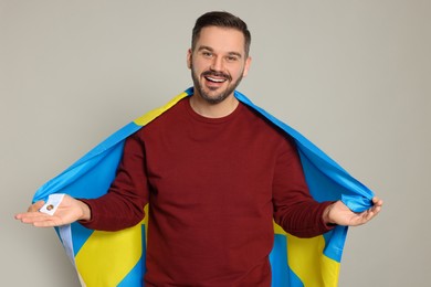 Man with flag of Sweden on light grey background