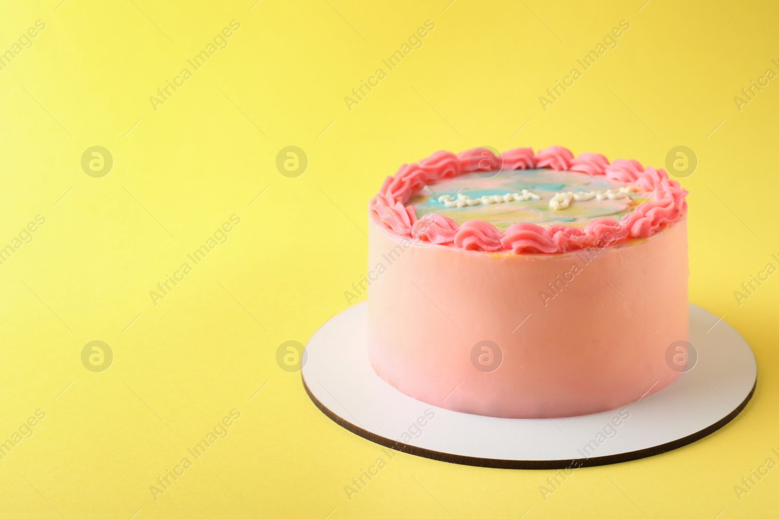 Photo of Cute bento cake with tasty cream on yellow background, space for text