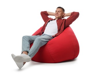 Photo of Handsome man resting on red bean bag chair against white background