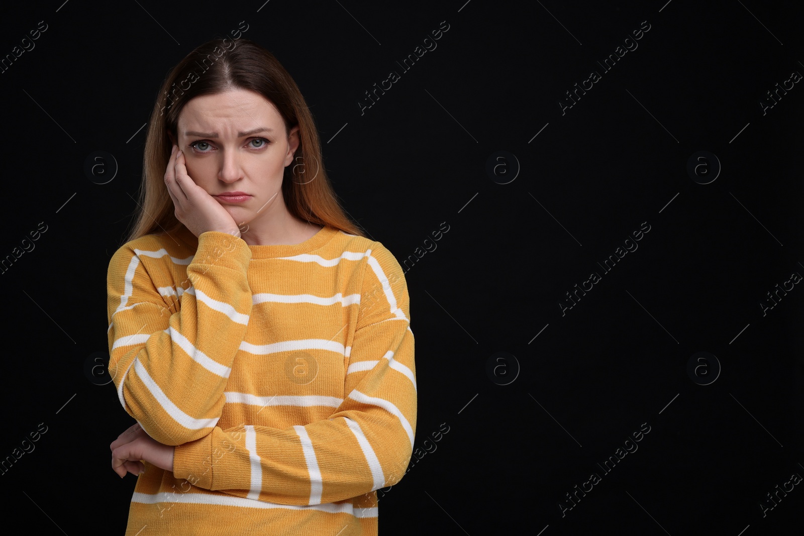 Photo of Portrait of sad woman on black background, space for text