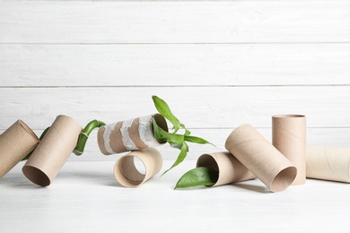 Composition with bamboo plant and empty toilet paper rolls on table. Space for text