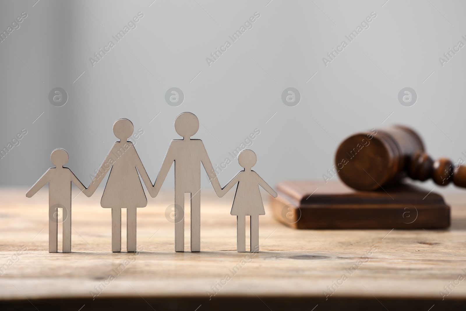 Photo of Family law. Figure of parents with children and gavel on wooden table, space for text