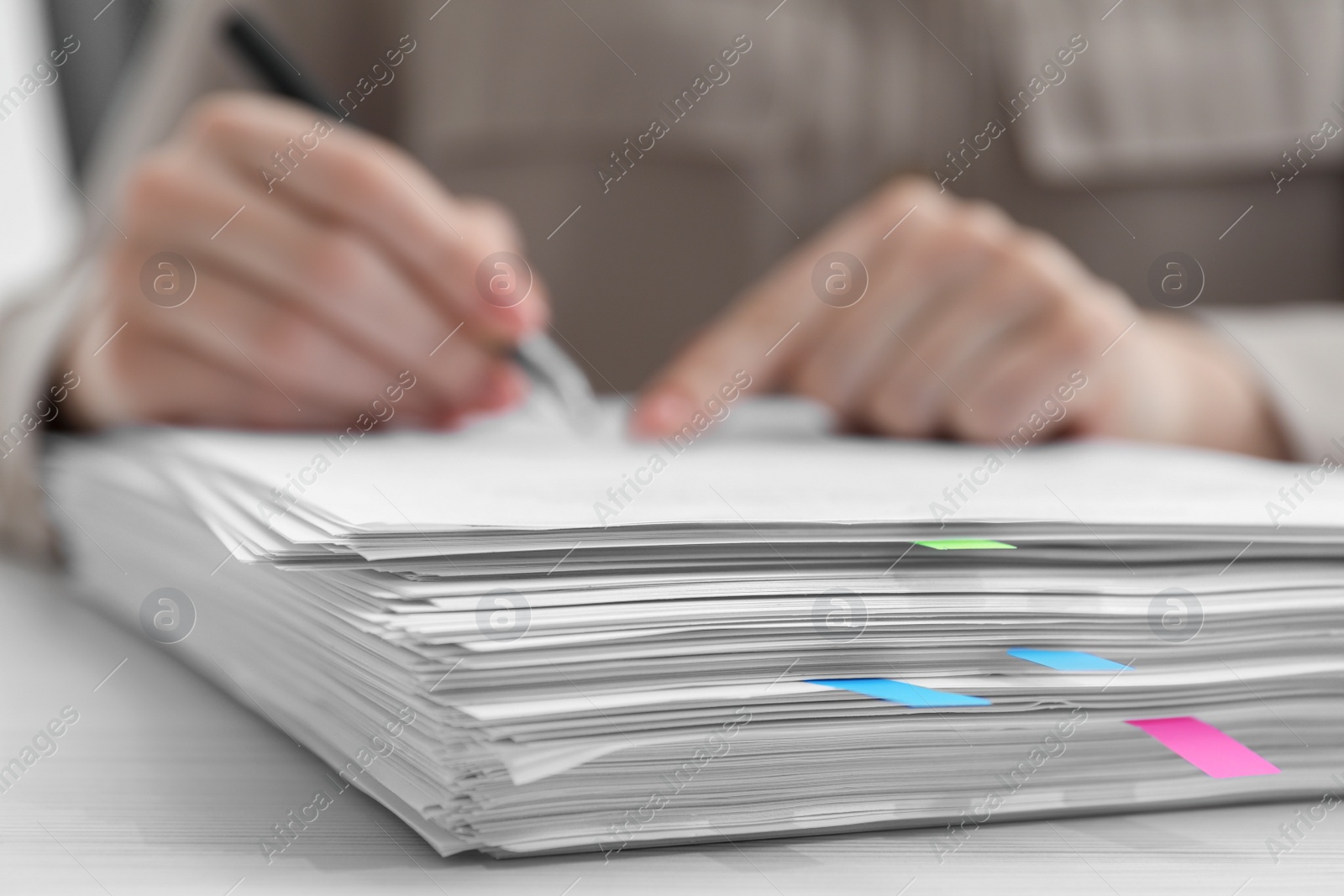 Photo of Woman signing documents at wooden table in office, closeup. Space for text