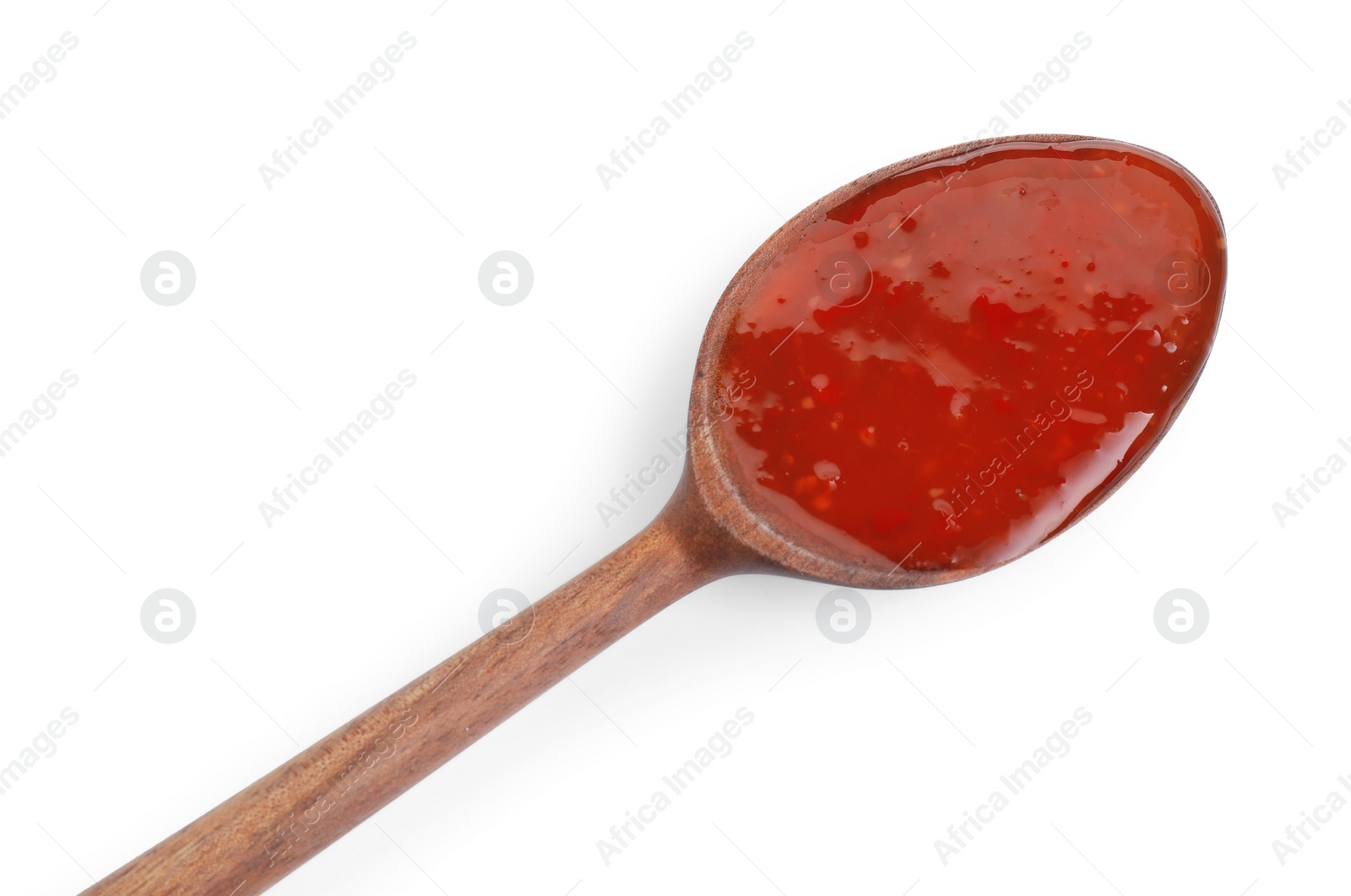 Photo of Spicy chili sauce in spoon isolated on white, top view