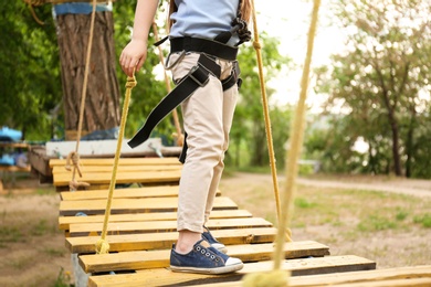 Little girl climbing in adventure park, closeup. Summer camp