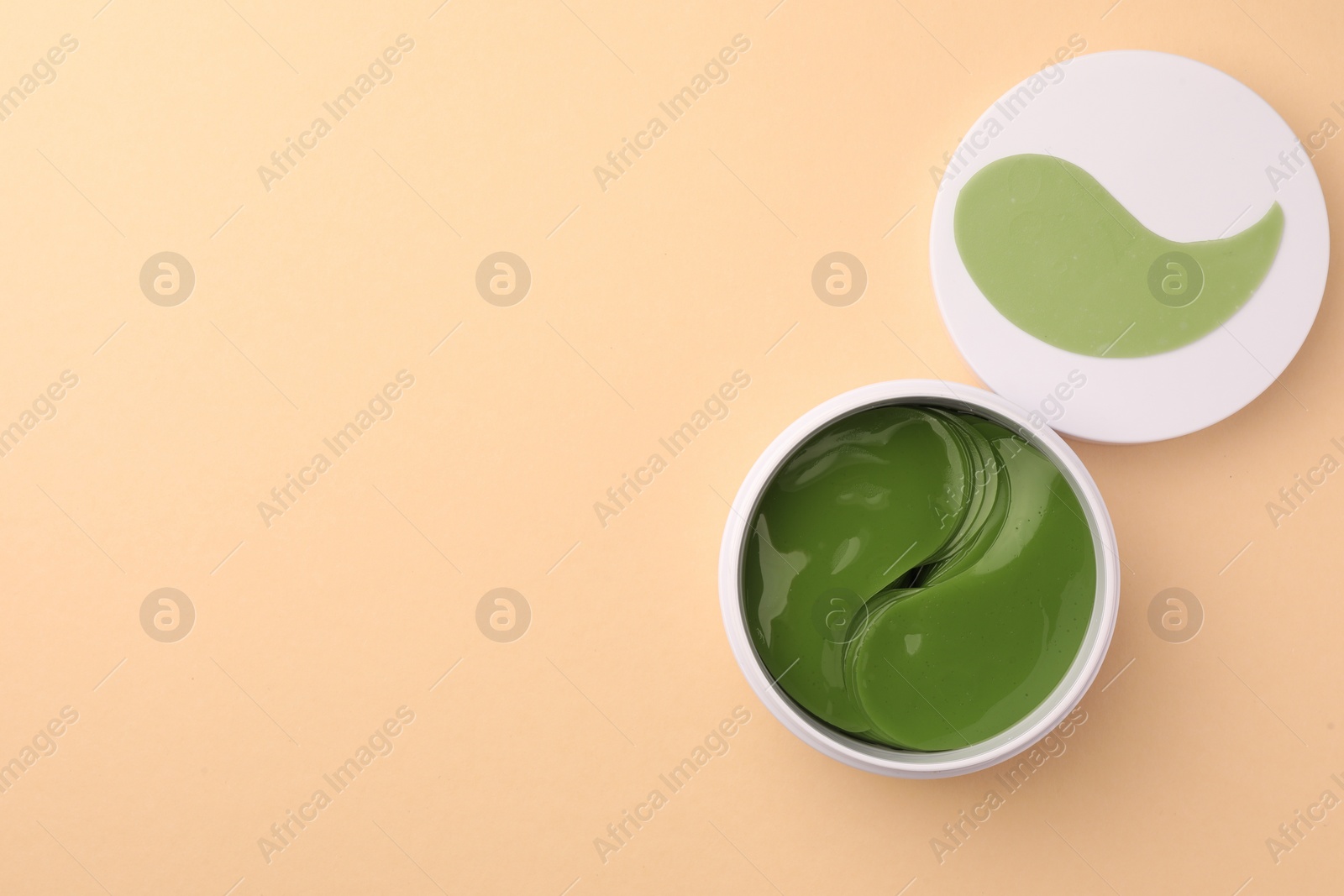 Photo of Jar of under eye patches on beige background, top view with space for text. Cosmetic product