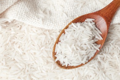 Photo of Raw basmati rice and spoon, top view. Space for text