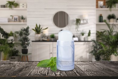 Image of Roll-on deodorant and mint on wooden table in bathroom. Mockup for design