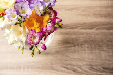 Beautiful bouquet of freesia flowers on table