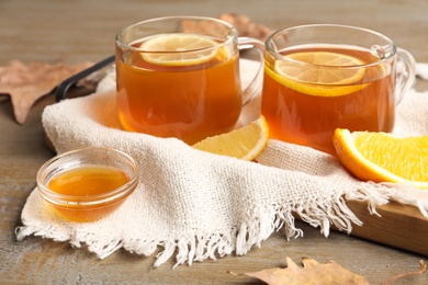 Photo of Hot tea with lemon slices and honey on wooden table