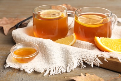 Hot tea with lemon slices and honey on wooden table