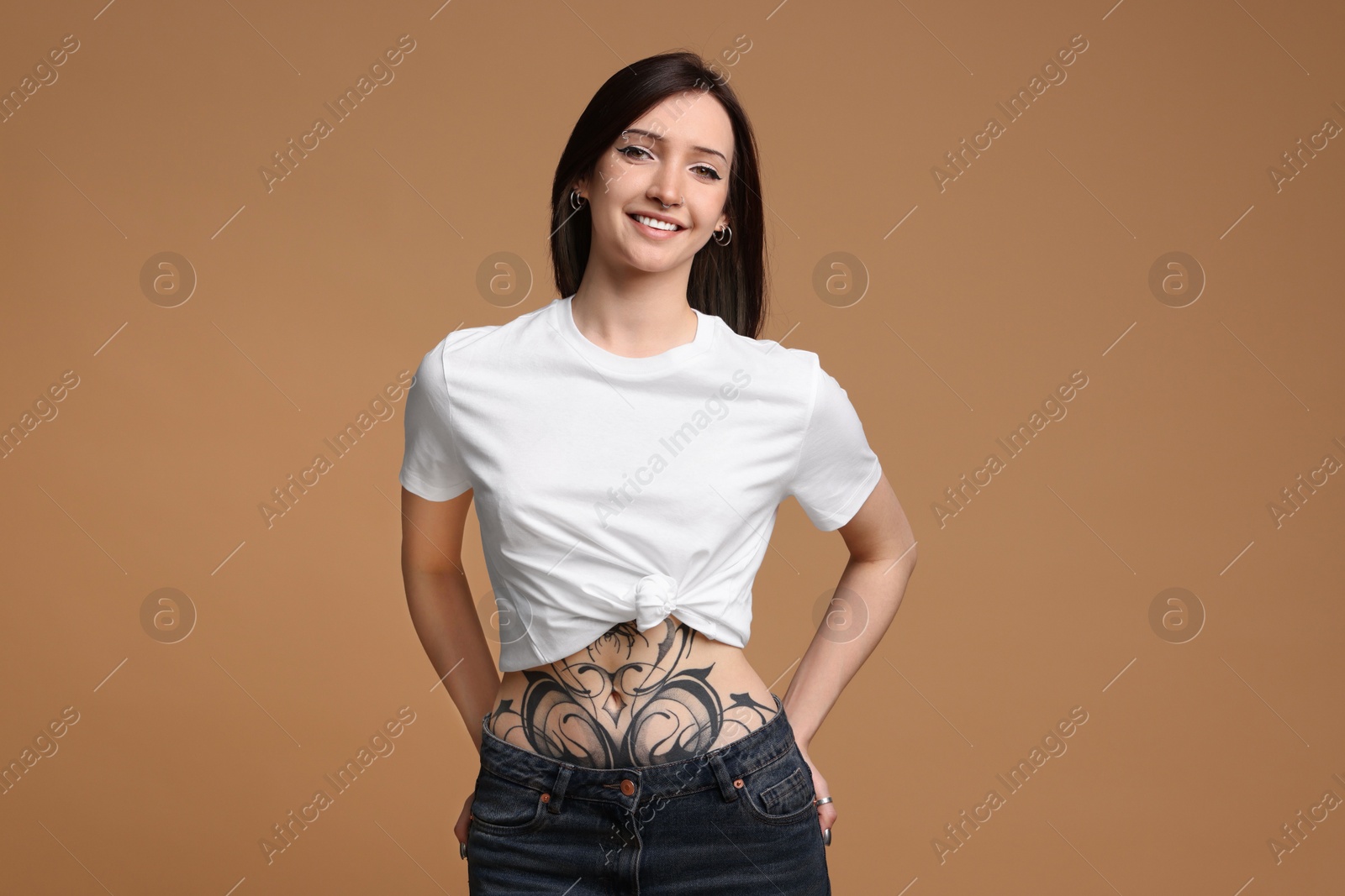 Photo of Portrait of smiling tattooed woman on beige background