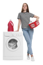 Beautiful young woman with laundry basket near washing machine on white background