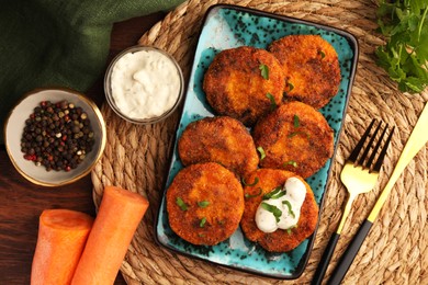 Photo of Tasty vegan cutlets with sauce and ingredients on wooden table, flat lay