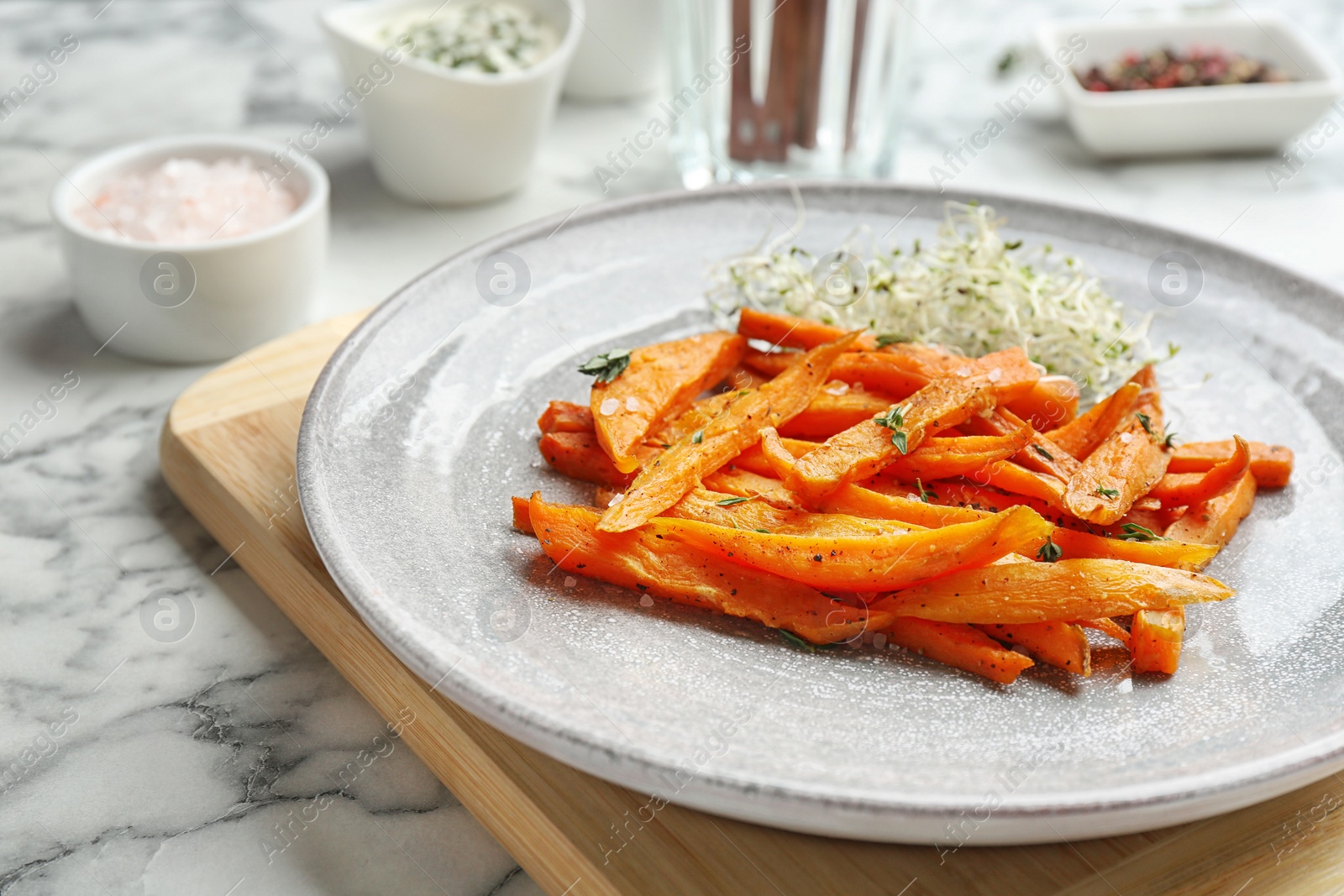 Photo of Plate with tasty sweet potato fries on marble table, closeup